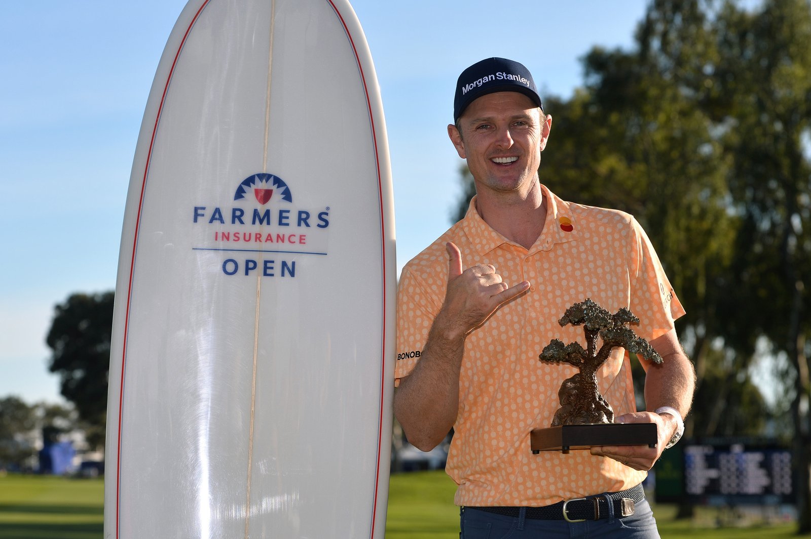 Justin Rose with Farmers trophy and surfboard